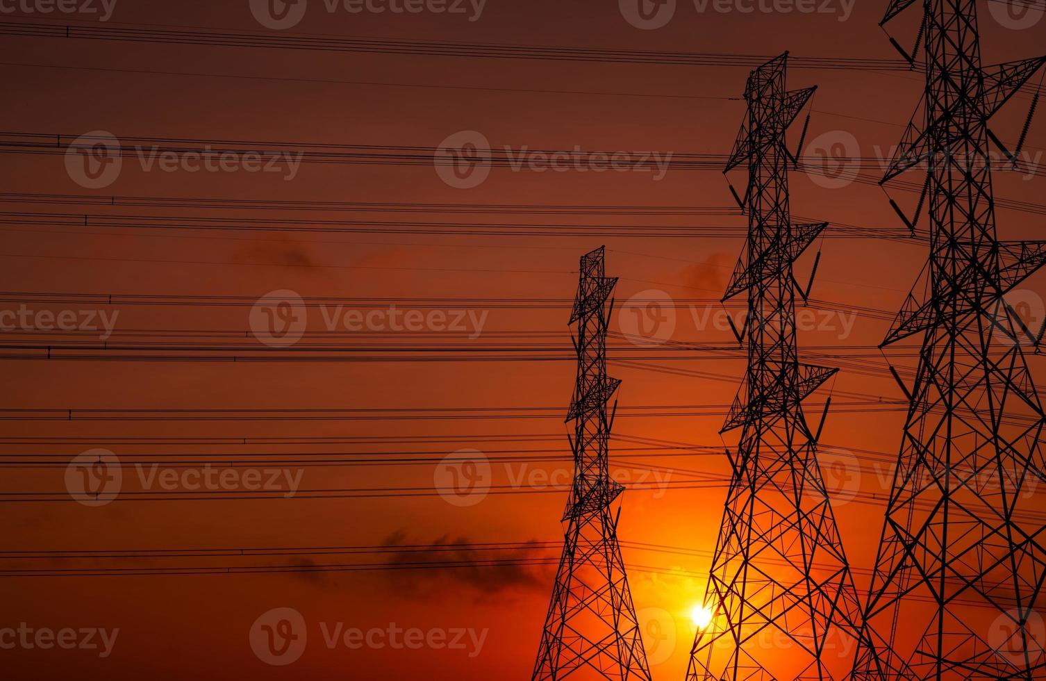 High voltage electric pole and transmission lines in the evening. Electricity pylons at sunset. Power and energy. Energy conservation. High voltage grid tower with wire cable at distribution station. photo