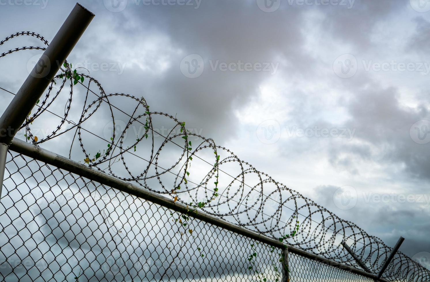 Prison security fence. Barbed wire security fence. Razor wire jail fence. Barrier border. Boundary security wall. Prison for arrest criminals or terrorists. Private area. Military zone concept. photo