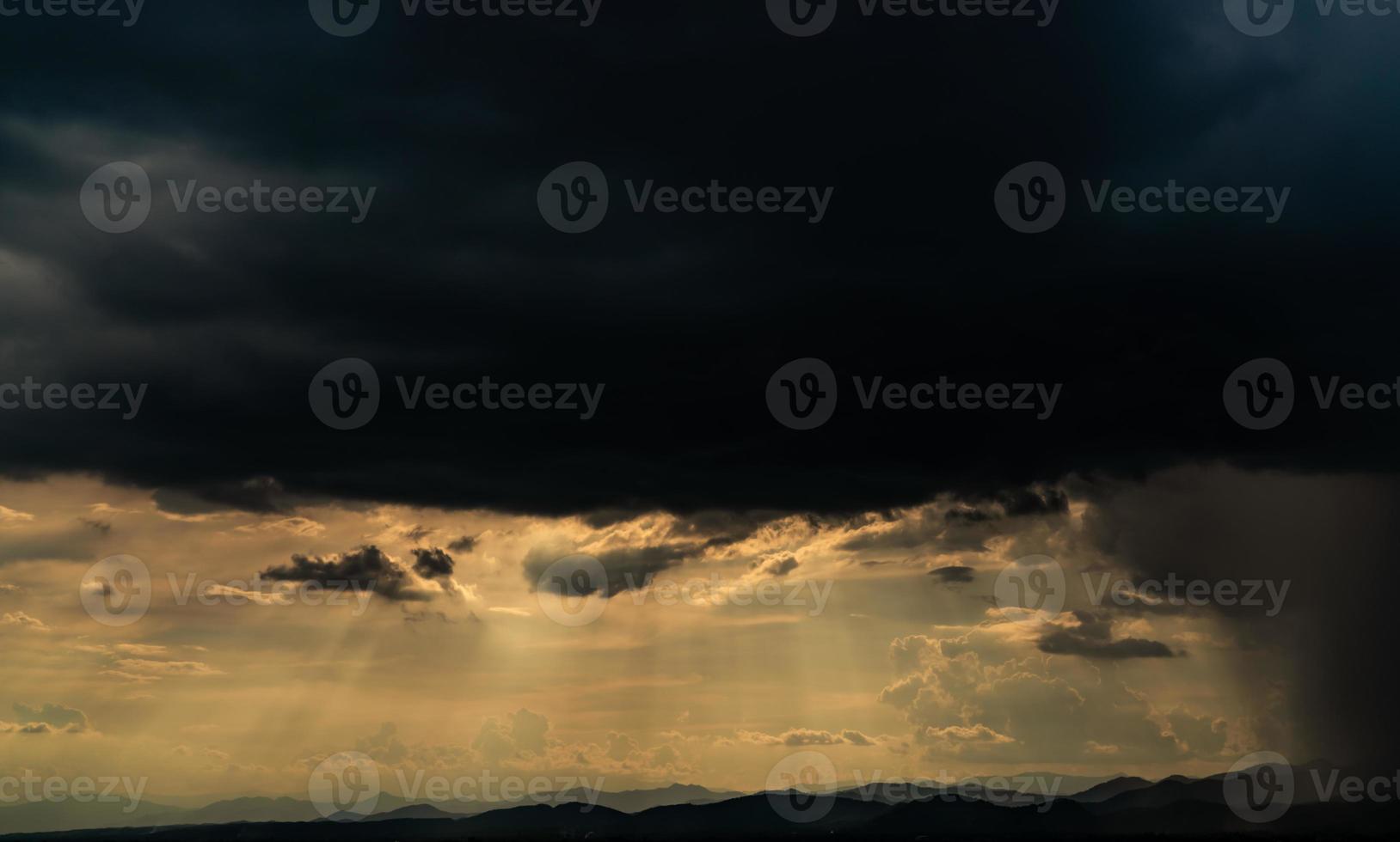 Heaven sky with god light over mountain range. Sun rays through dark clouds. Stormy sky. Golden sunlight shine from heaven sky for hope and faithful. Landscape of mountain layer. Beauty in nature. photo