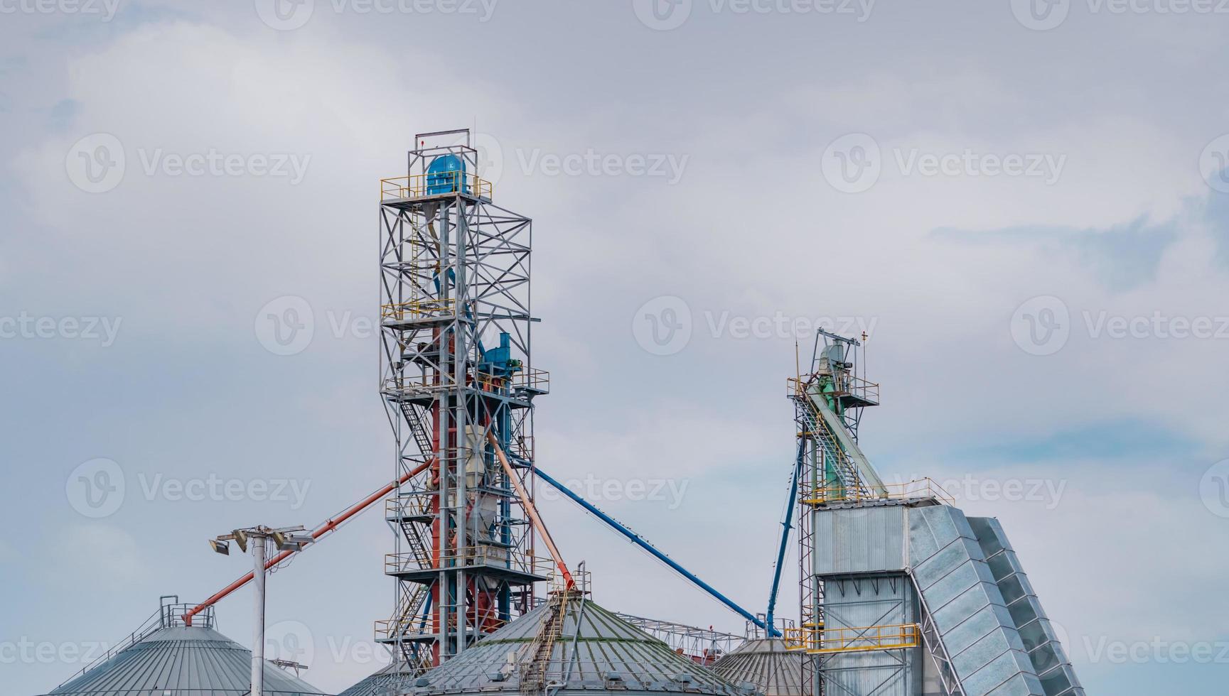 Agricultural silo at feed mill factory. Big tank for store grain in feed manufacturing. Seed stock tower for animal feed production. Commercial feed for livestock, swine and fish industries. photo