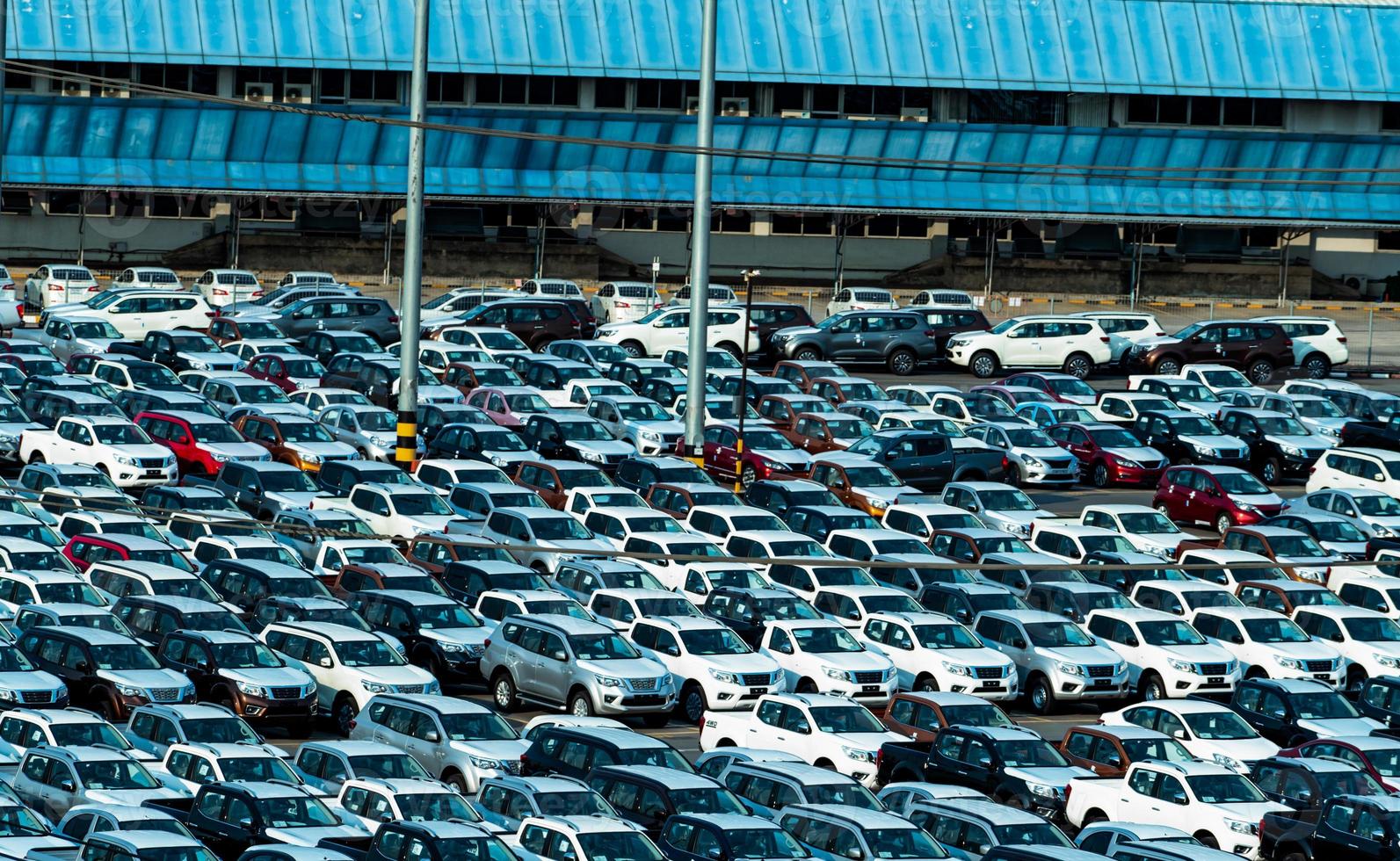 coche nuevo estacionado en fila en el estacionamiento de la fábrica. Stock de inventario del concesionario de automóviles. industria automotriz. concepto de concesionario de automóviles. zona de aparcamiento de hormigón para stock car después de la línea de producción en la fabricación. foto