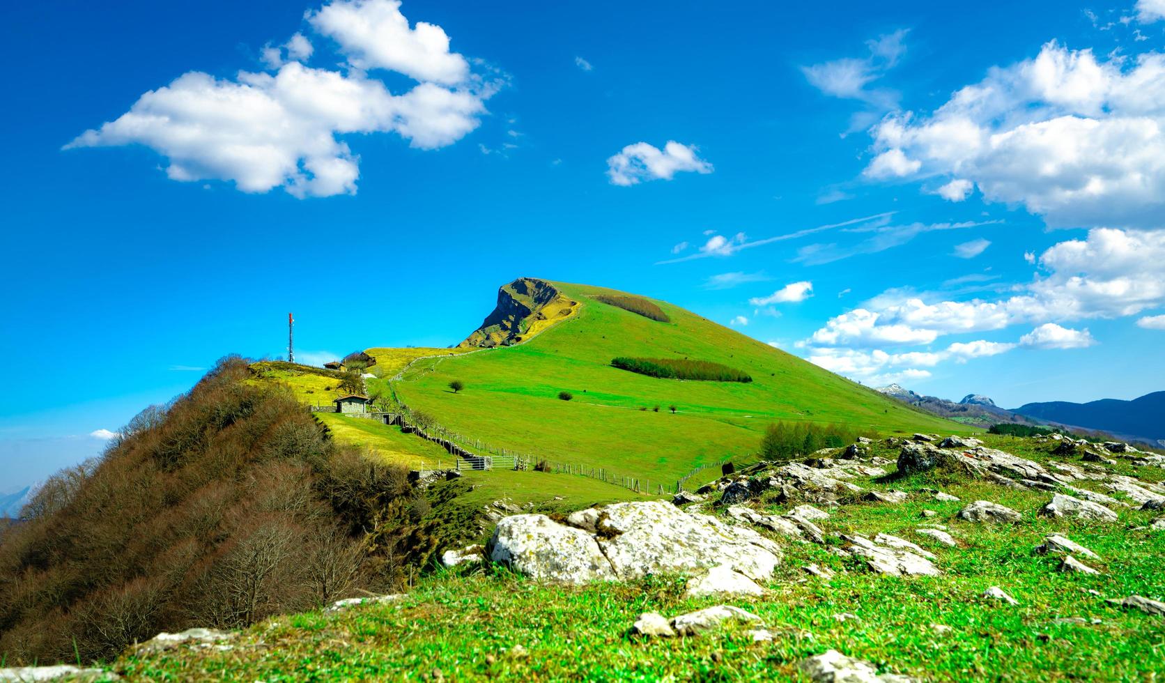 Landscape of rock mountain. Hill with beautiful sky and white clouds on sunny day. Farming ranch. Animal pasture.  Landscape of green grass field and pine tree. Countryside grassland in spring. photo
