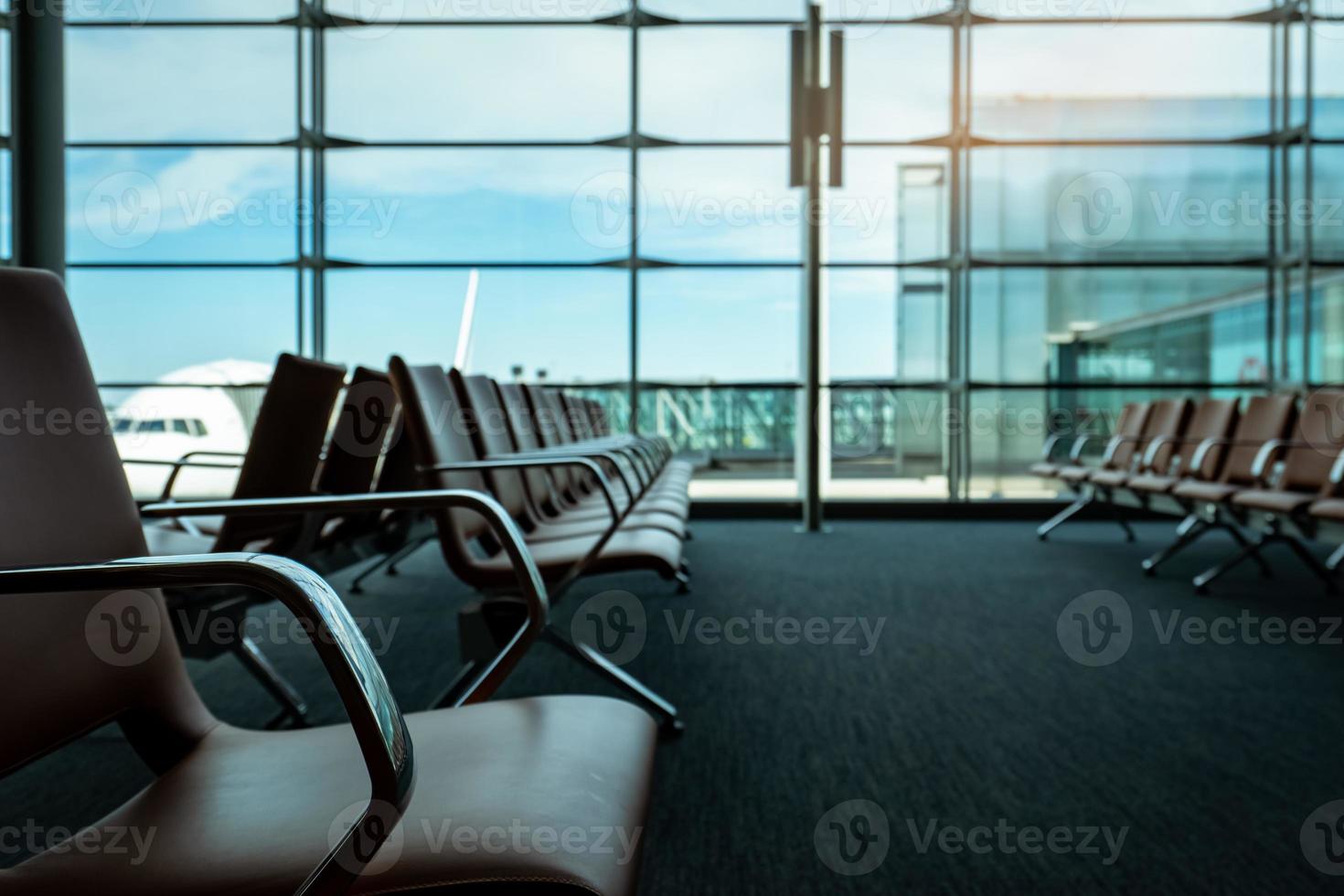 Passenger seats in departure lounge at airport terminal. Interior of airport terminal. Chairs in departure area at international gate. Transport business and travel. Empty seat for waiting flight. photo