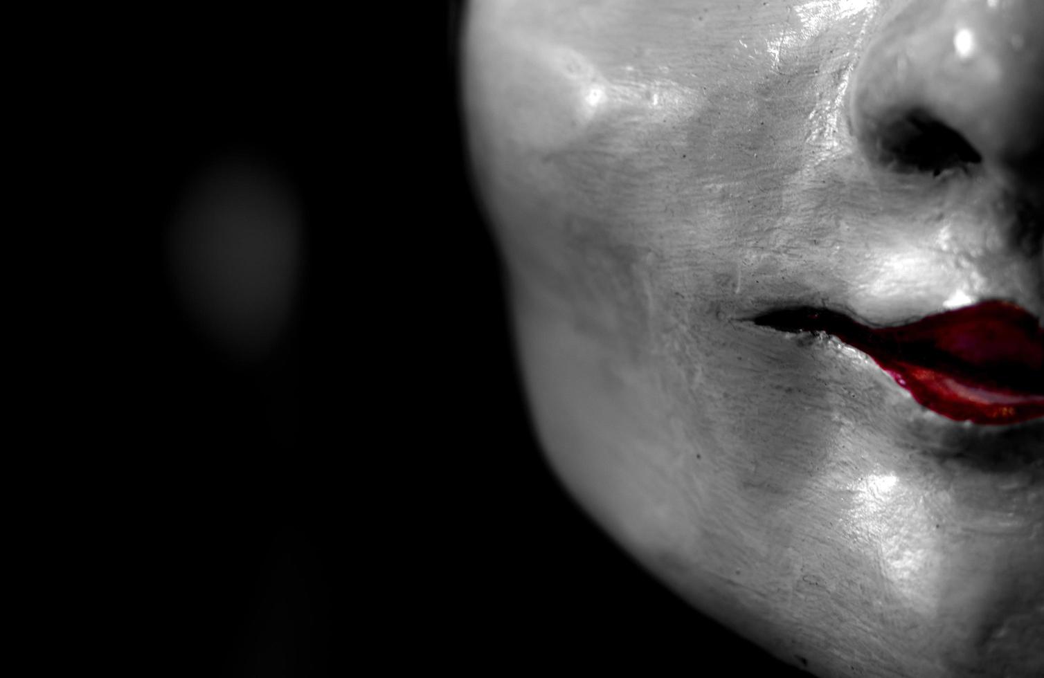 Statue face of woman made of plaster. Statue face of woman on dark background. Sculpture art. Statue face of woman looking for something. Red lips. photo