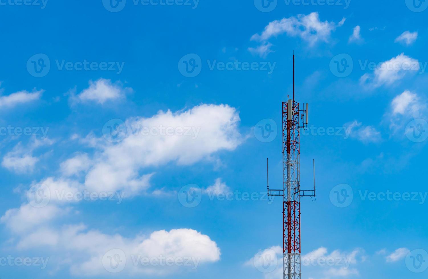 Telecommunication tower with blue sky and white clouds background. Antenna on blue sky. Radio and satellite pole. Communication technology. Telecommunication industry. Mobile or telecom 4g network. photo