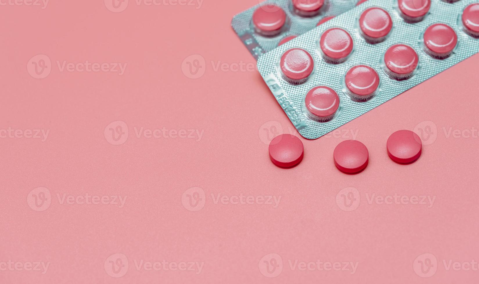 vista superior píldora de tabletas de color rosa sobre fondo de color rosa. banner web de atención médica. vitaminas y suplementos para la mujer. industria farmacéutica. cáncer de mama o temas de salud de la mujer. concepto del día mundial de la salud. foto