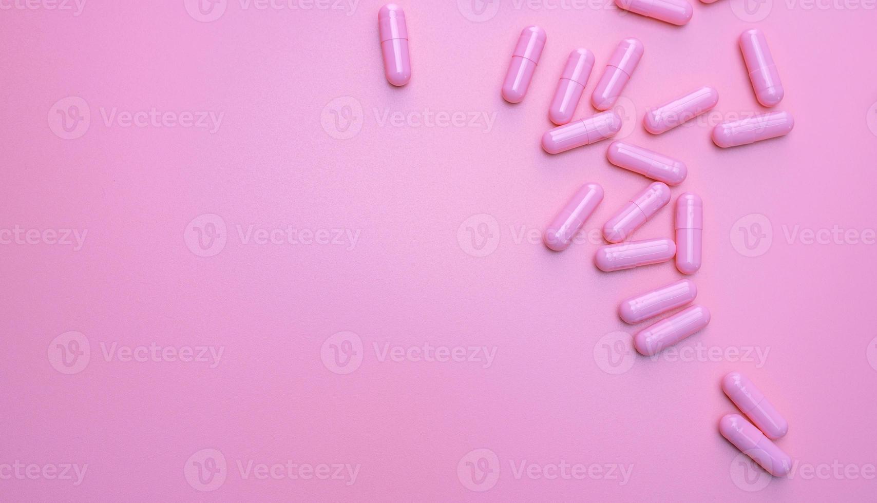 Pink antibiotic capsule pills spread on pink background. Antibiotic drug resistance. Pharmaceutical industry. Healthcare and medicine concept. Health budget concept. Capsule manufacturing industry. photo