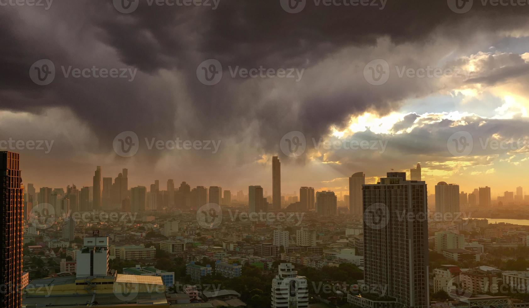 paisaje urbano con edificio de rascacielos. la luz del sol de la mañana a través del cielo con nubes grises. ciudad ribereña con amanecer dorado. edificio urbano moderno. lleno de negocios y edificio del centro financiero. foto