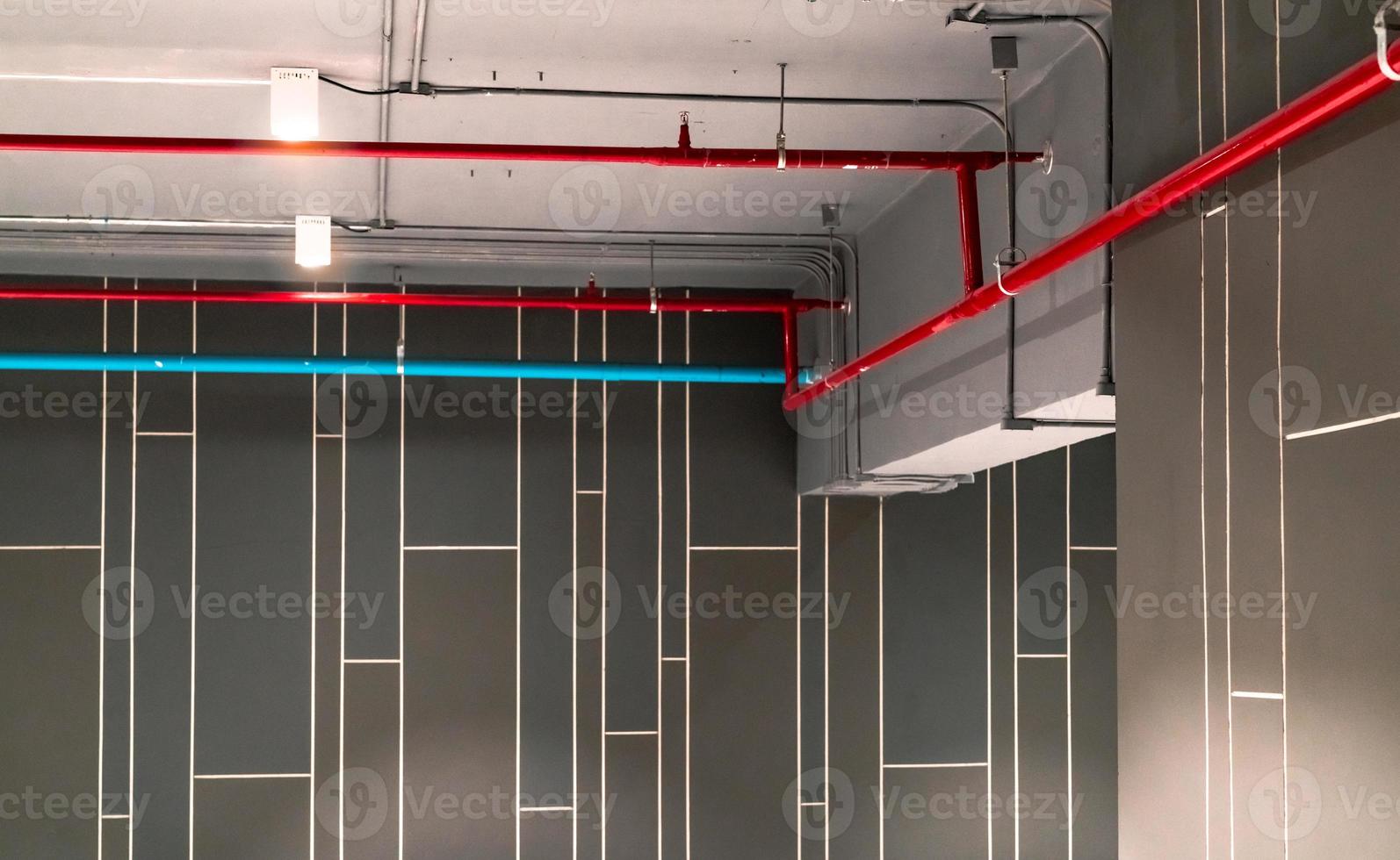 Automatic fire sprinkler safety system and red water supply pipe. Fire Suppression. Fire protection and detector. Fire sprinkler system with red pipe hanging from ceiling inside building. Wiring tube. photo