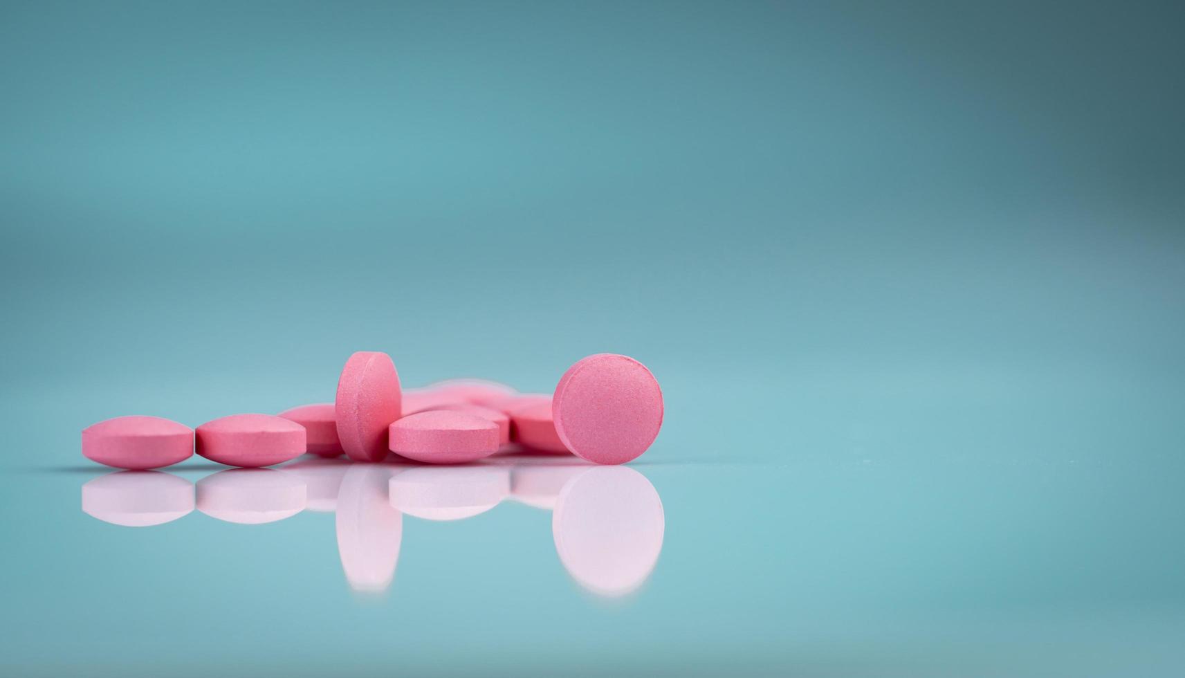 píldora de tabletas redondas de color rosa sobre fondo degradado. vitaminas y minerales además de ácido fólico vitamina e y zinc. Pastillas rosadas para la mujer durante y después del embarazo. industria farmacéutica. farmacéutico foto