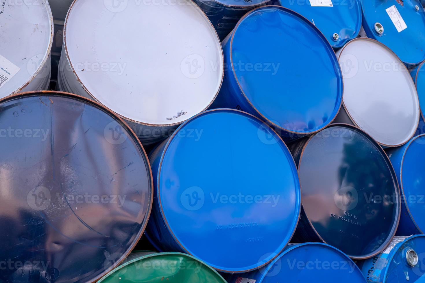 Old chemical barrels. Blue, white, and green oil drum. Steel oil tank. Toxic waste warehouse. Hazard chemical barrel. Industrial waste in old drum. Hazard waste storage in factory. Metal barrels. photo