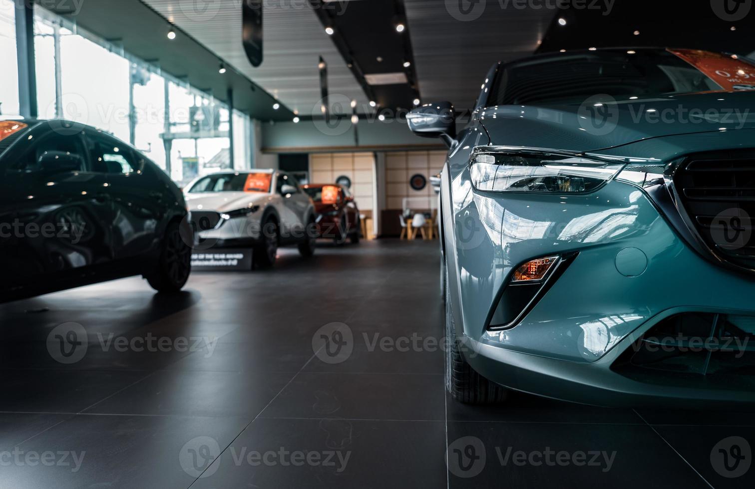 Selective focus grey car parked in luxury showroom. Car dealership office. New car parked in modern showroom. Car for sale and rent business concept. Automobile leasing and insurance background. photo