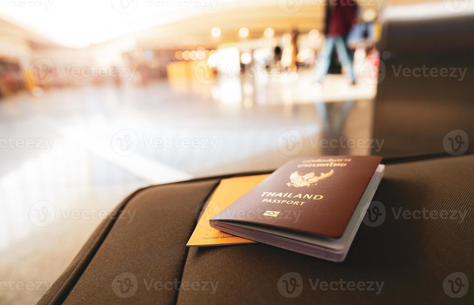 pasaporte de tailandia y pasaporte de vacunas en equipaje sobre fondo borroso de turista en el aeropuerto. certificado de vacunación para viajar durante el brote de coronavirus. documento para viajar después del covid-19. foto