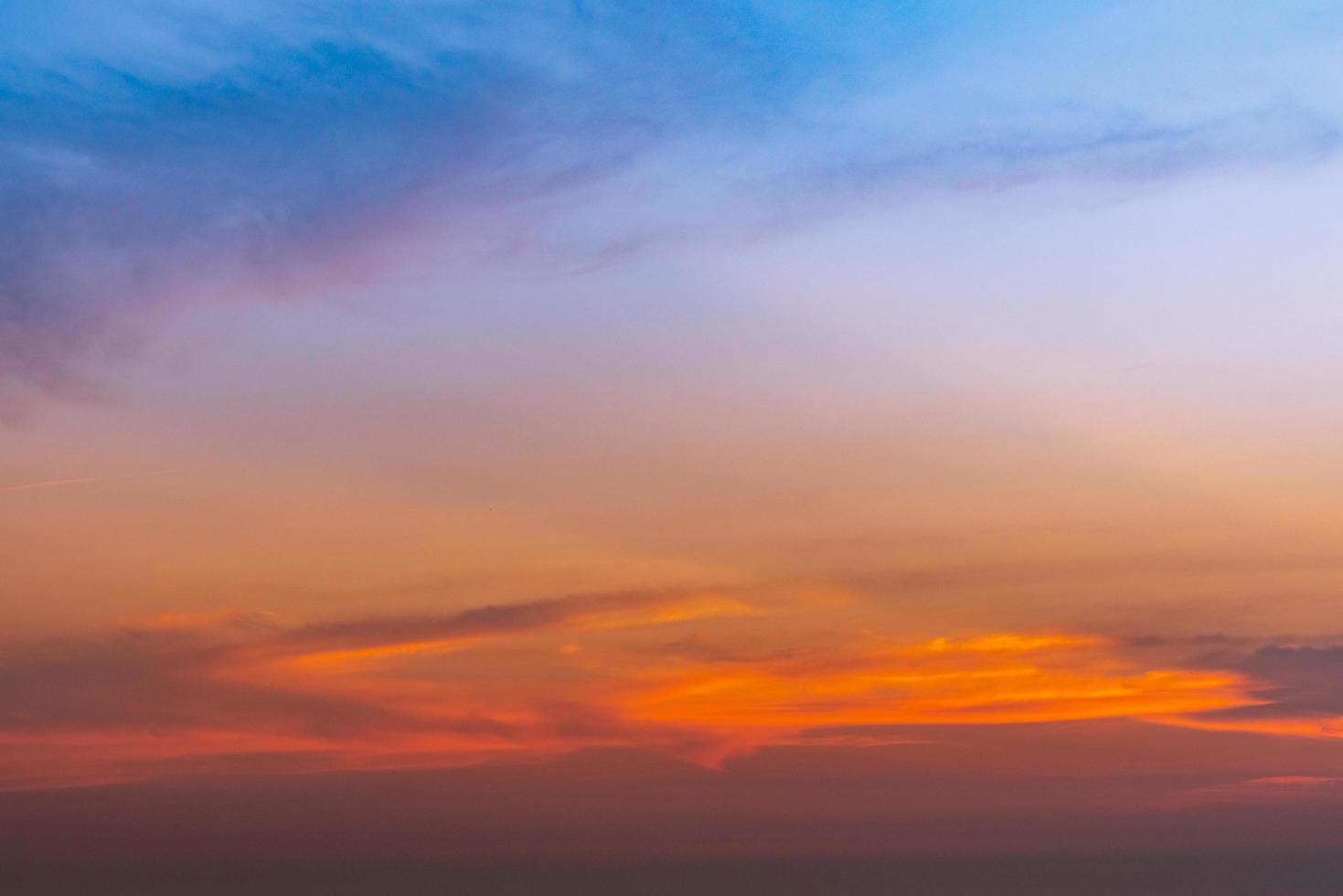 Dramatic blue and orange sky and clouds abstract background. Red-orange clouds on sunset sky. Warm weather background. Art picture of sky at dusk. Sunset abstract background. Dusk and dawn concept photo