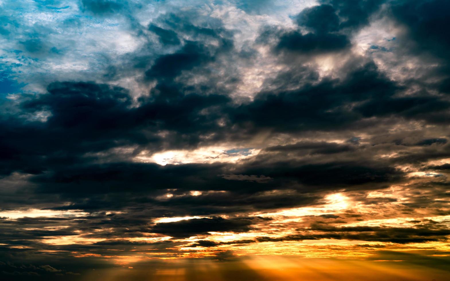 dios luz. espectacular cielo nublado oscuro con rayo de sol. rayos de sol amarillos a través de nubes oscuras y grises. luz de dios del cielo para la esperanza y el concepto fiel. creer en Dios. fondo hermoso del cielo de la luz del sol foto