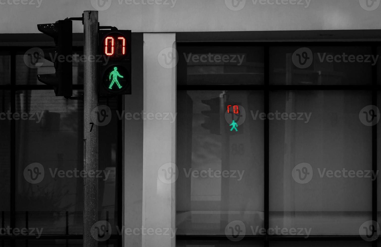 Pedestrian signals on traffic light pole. Pedestrian crossing sign for safe to walk in the city. Crosswalk signal. Green traffic light signal and 7 seconds left to walk across the road. photo
