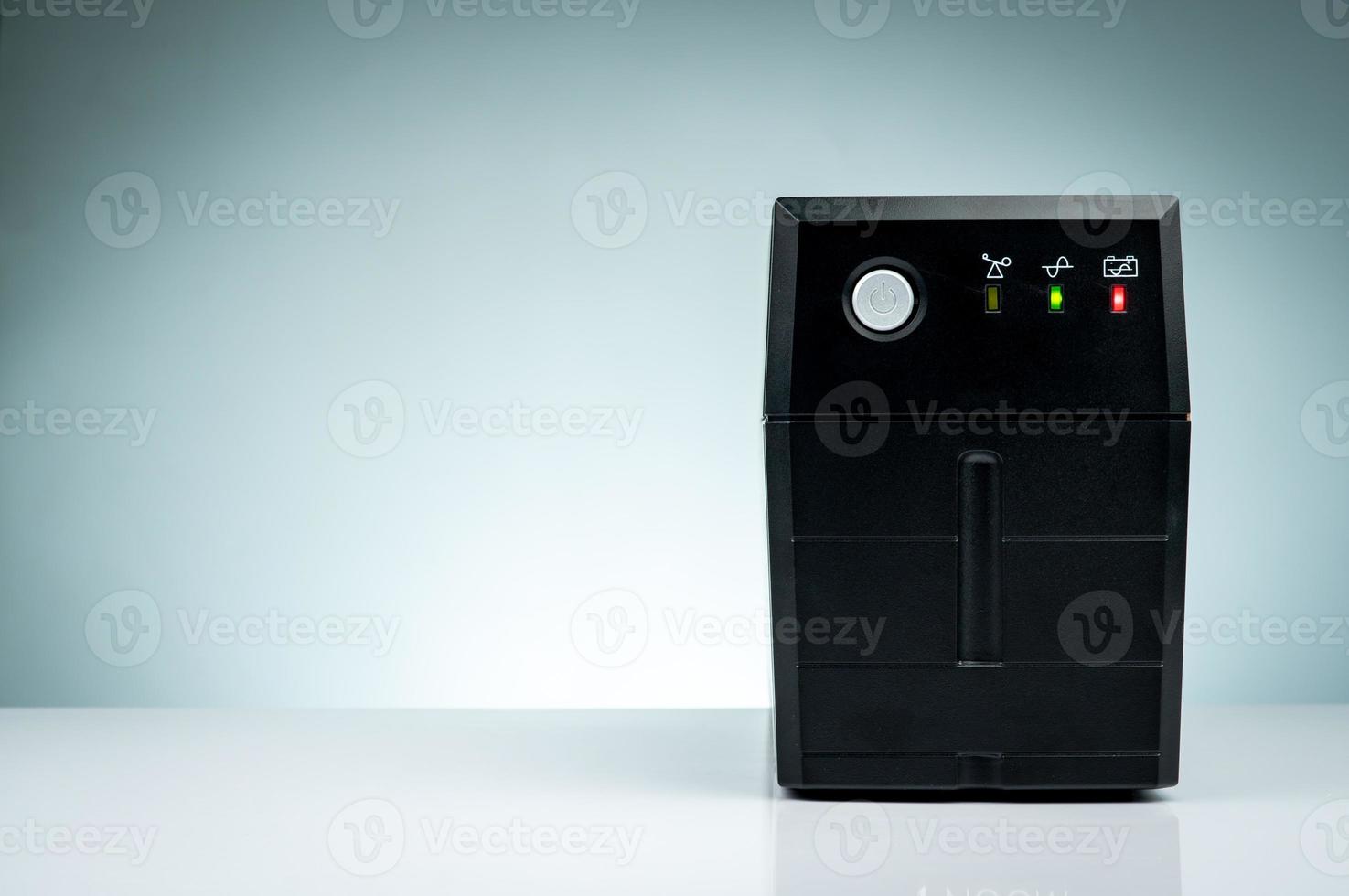 Uninterruptible power supply. Backup Power UPS with battery isolated on table. UPS for PC. Equipment for computer system at office for security. Power protection solutions from home to data center. photo