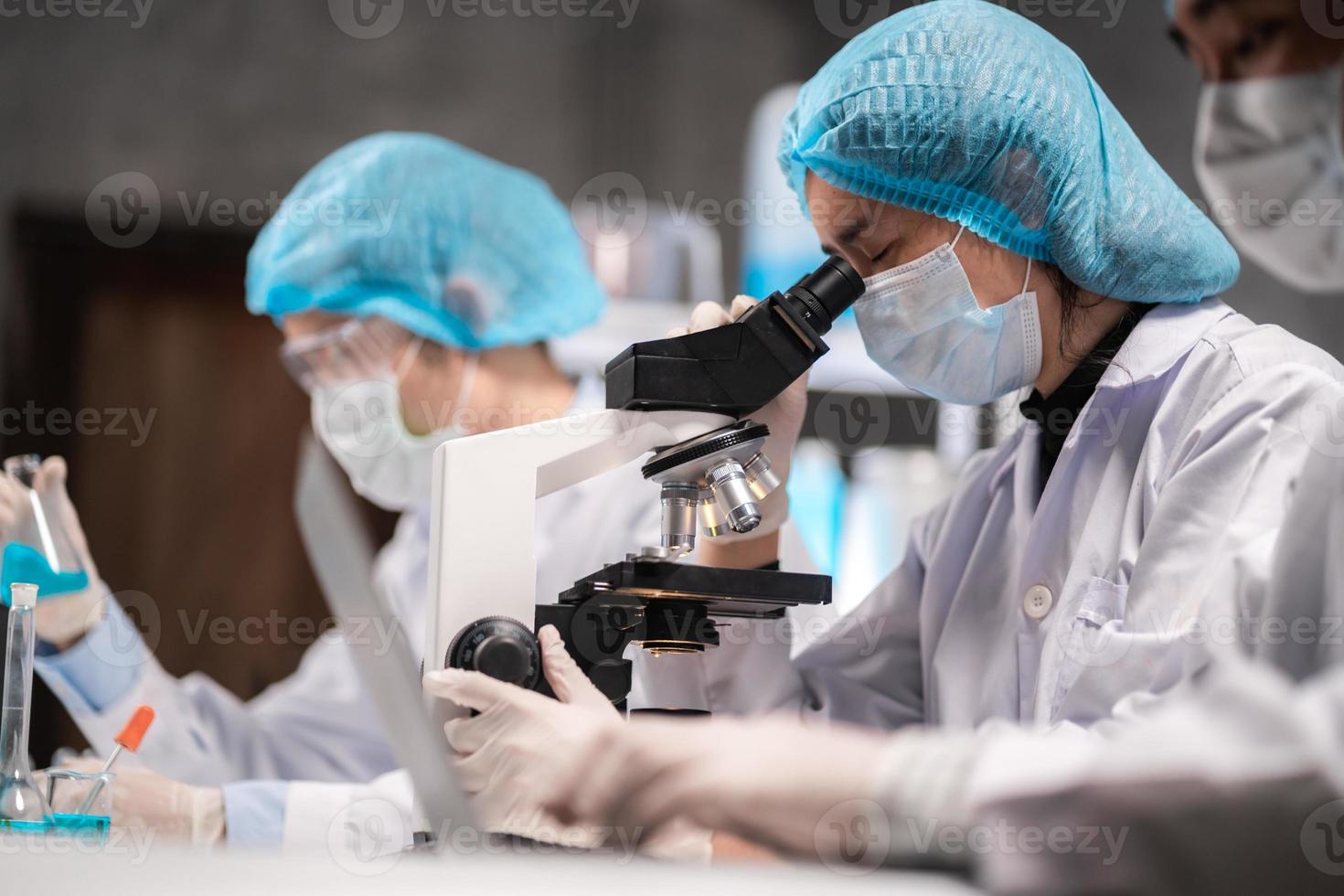 scientist looking through scientific microscope lense in laboratory, scientist doing research in term of medicine biotechnology biology or chemistry, doctor analyzing work in medical microbiology lab photo