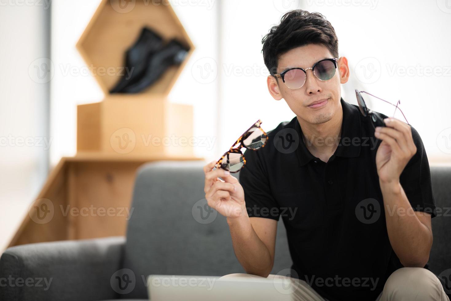 online sale and social media marketing concept, young Asian man working with camera to live streaming to sale a product and showing packet to review, broadcast cyberspace and blog shop photo