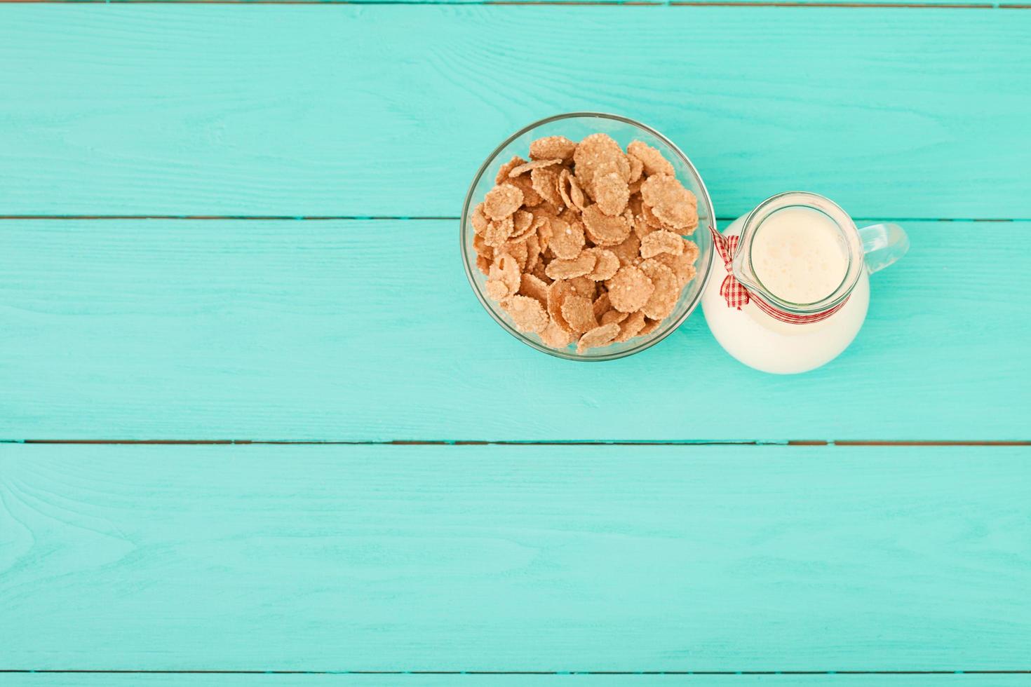 Milk, cookie, oat flakes. Breakfast and pink rose on blue wooden background and lace napkin. Top view and copy space. Mothers day. photo