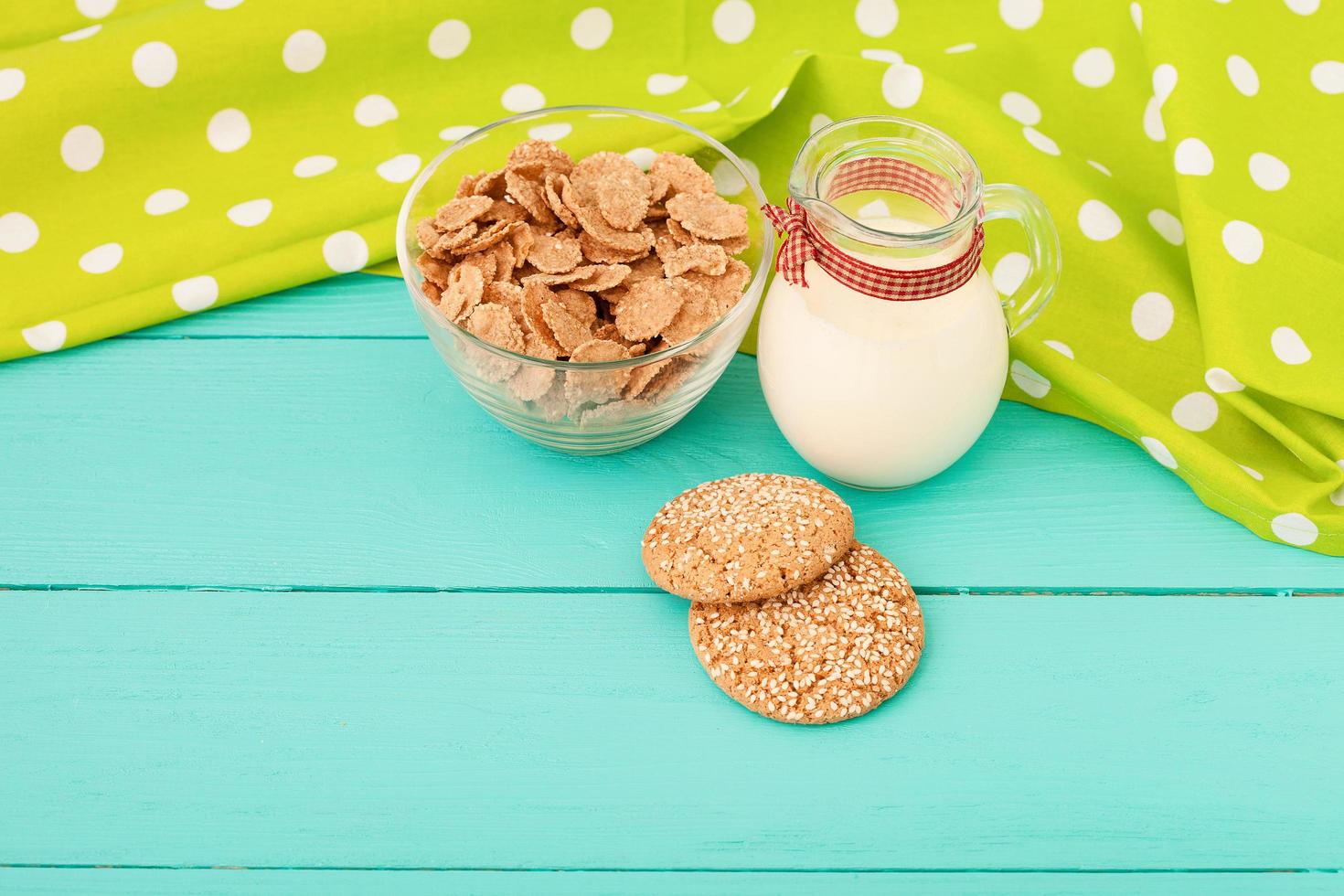 Milk, cookie, oat flakes. Breakfast and pink rose on blue wooden background and lace napkin. Top view and copy space. Mothers day. photo