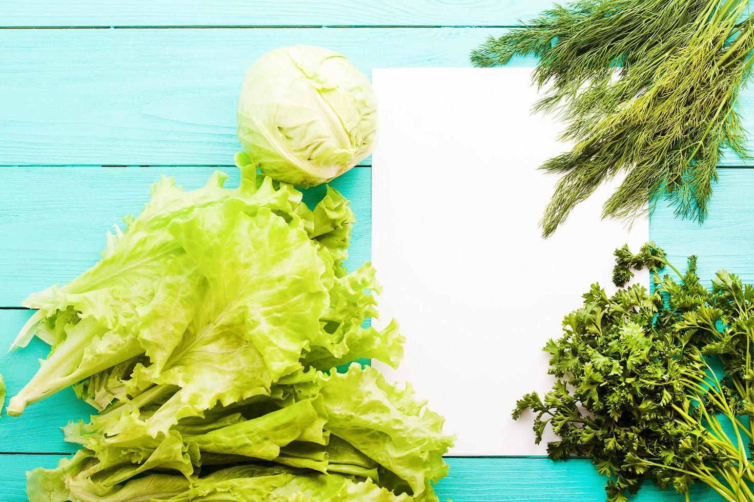 Different vegetables on kitchen table with recipe list and copy space. Top view photo