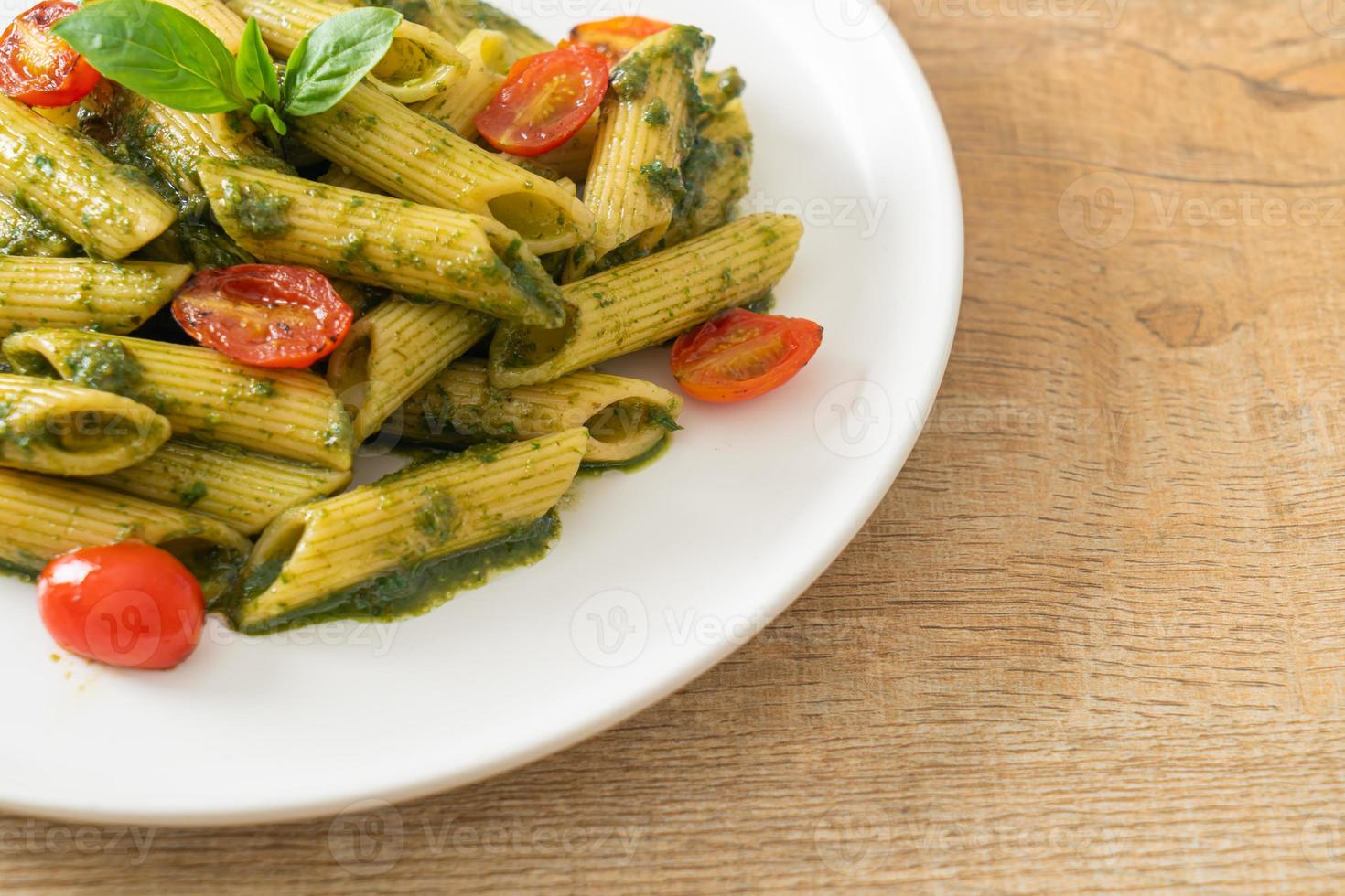 penne pasta with pesto sauce and tomatoes photo