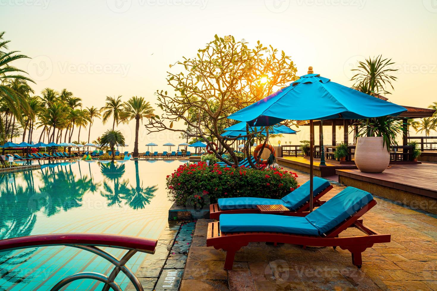 Hermosa sombrilla y silla alrededor de la piscina en el hotel y resort foto