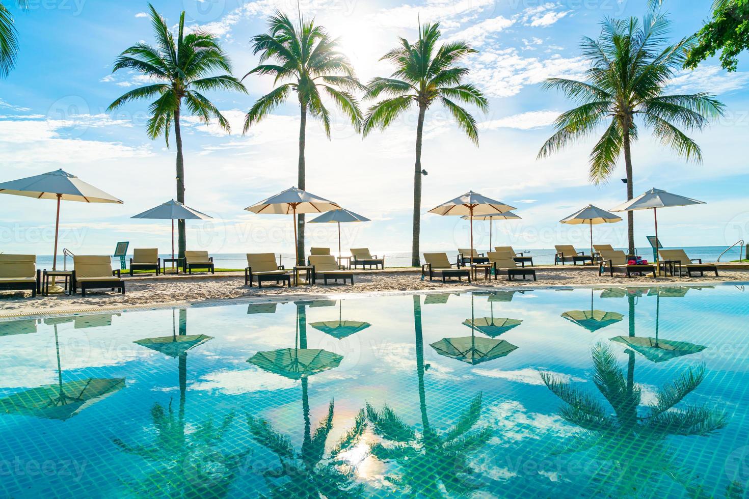 Beautiful umbrella and chair around swimming pool in hotel and resort photo