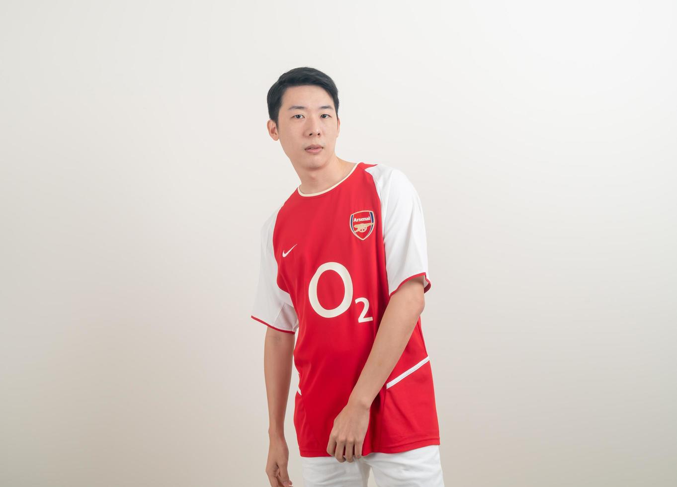 Bangkok, THAILAND - Nov 27, 2021 - Young Asian man wearing Arsenal shirt with white background. photo
