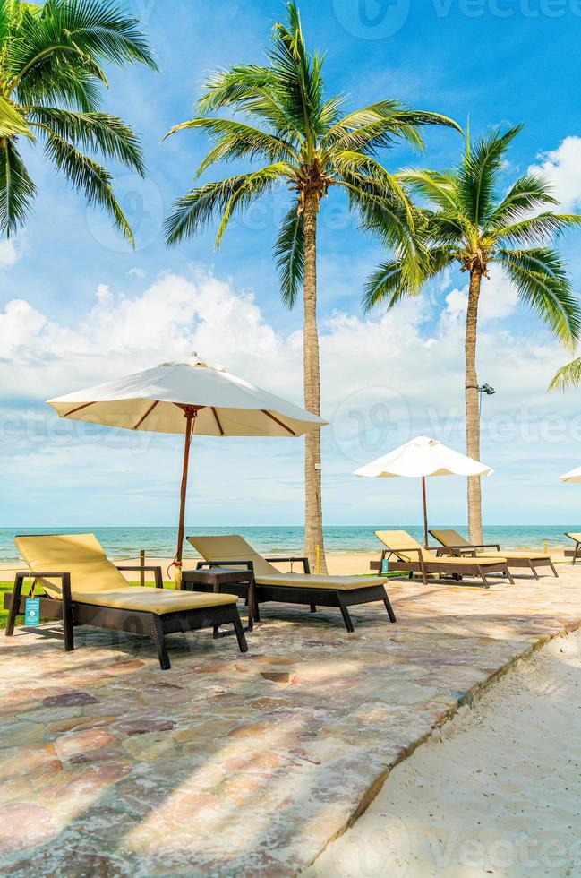 Hermosa playa tropical y mar con sombrilla y silla alrededor de la piscina en el complejo hotelero foto