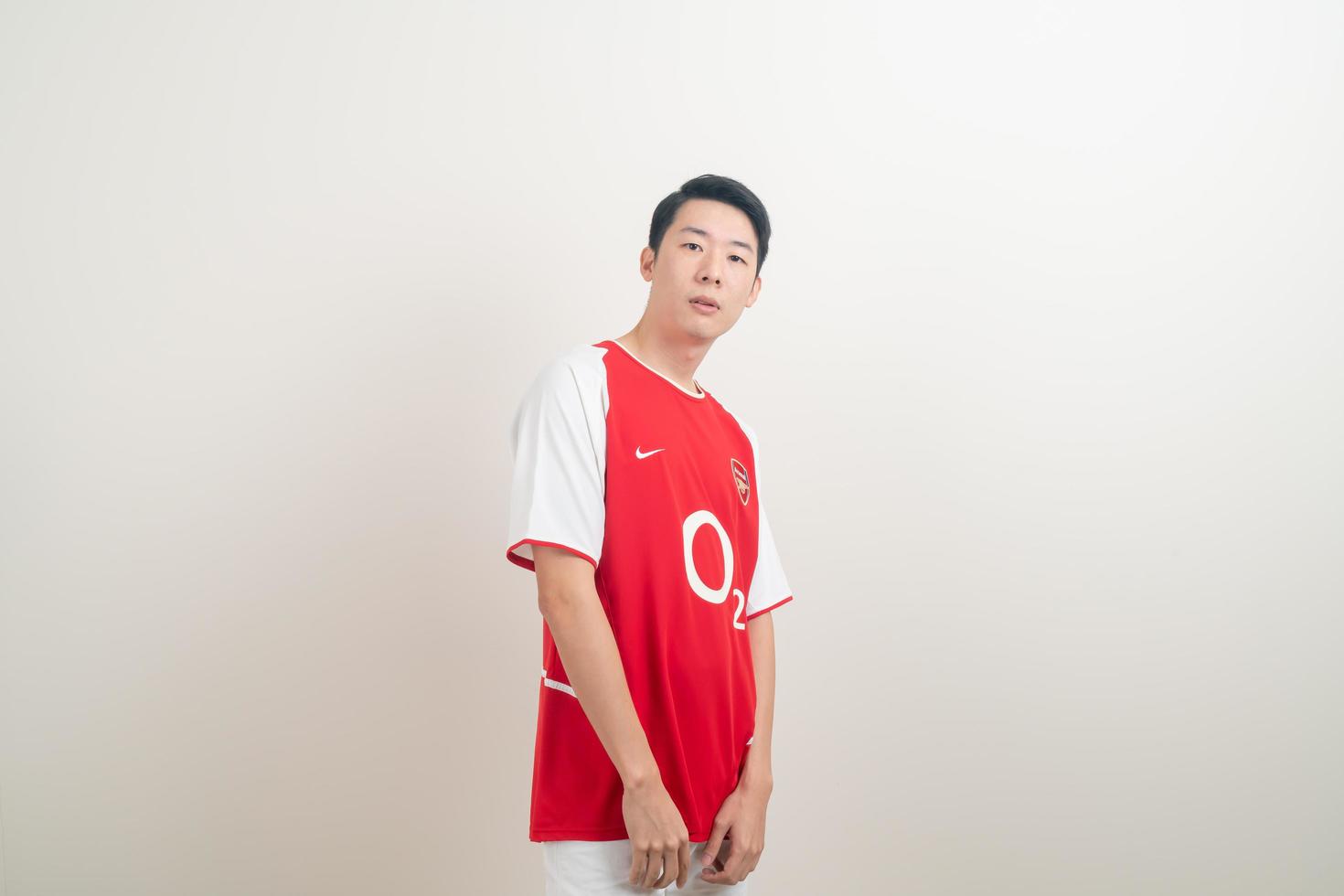 Bangkok, Tailandia - 27 de noviembre de 2021 - joven asiático vistiendo la camiseta del arsenal con fondo blanco. foto