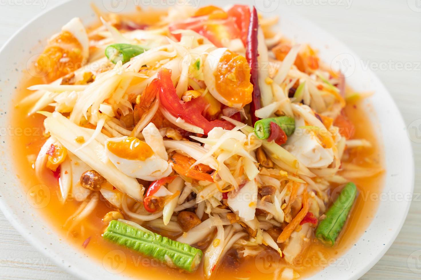 Som Tum - Thai Spicy green papaya salad with salty eggs photo