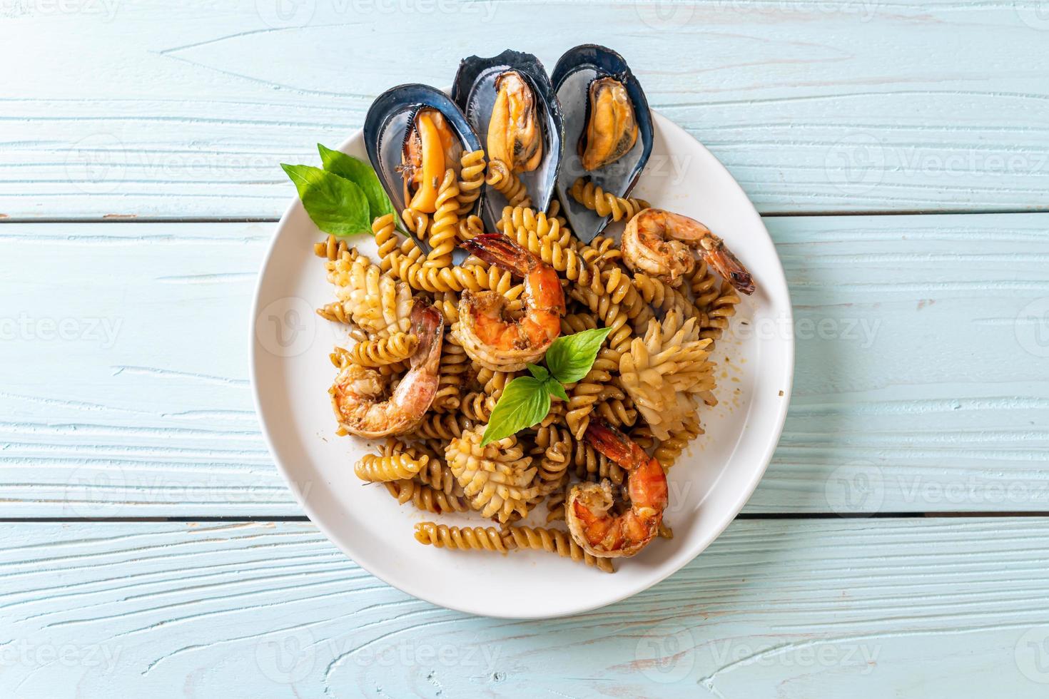 stir-fried spiral pasta with seafood and basil sauce photo