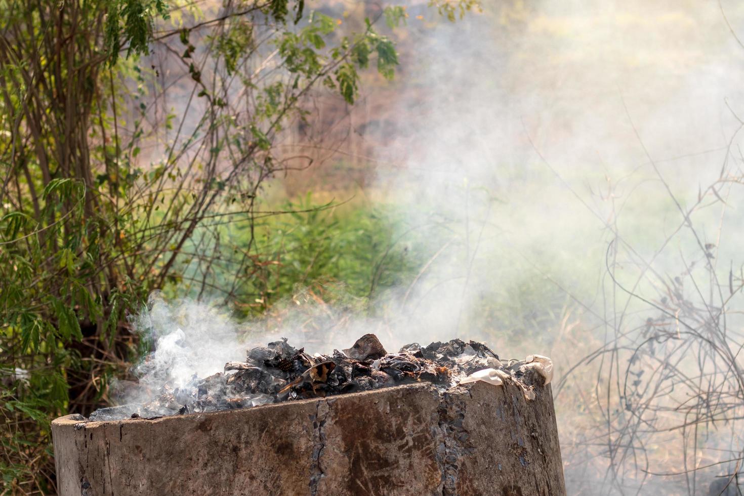 Old concrete tanks burn waste, causing smoke. photo