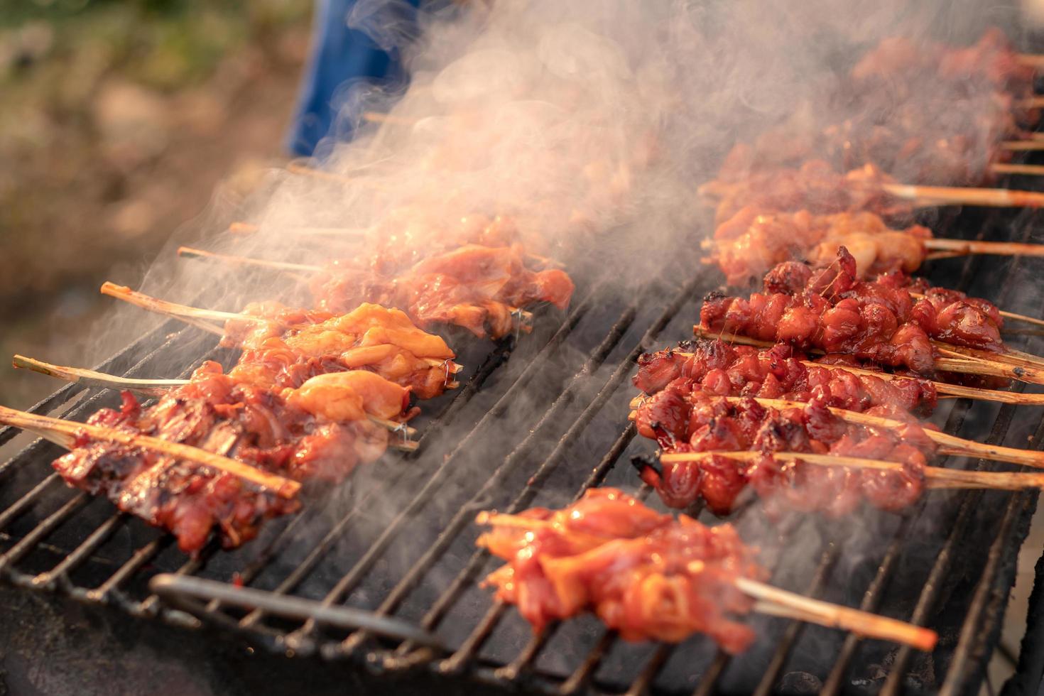 brochetas de pollo a la parrilla con humo. foto