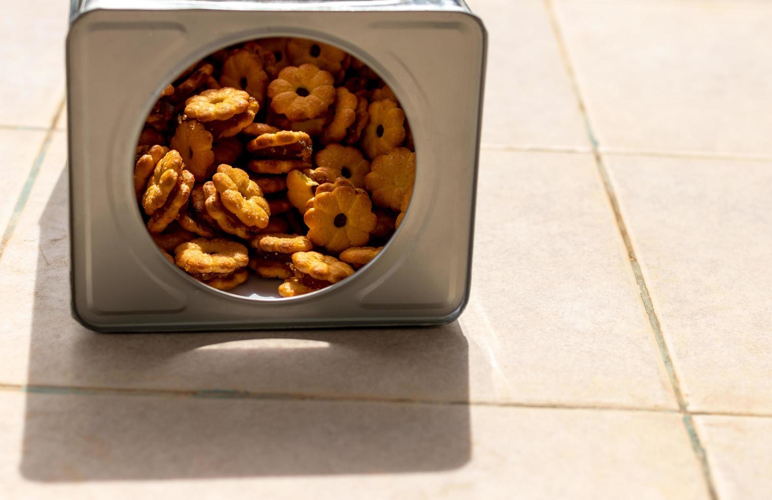 Many pineapple biscuit desserts are stacked on the concrete floor. photo