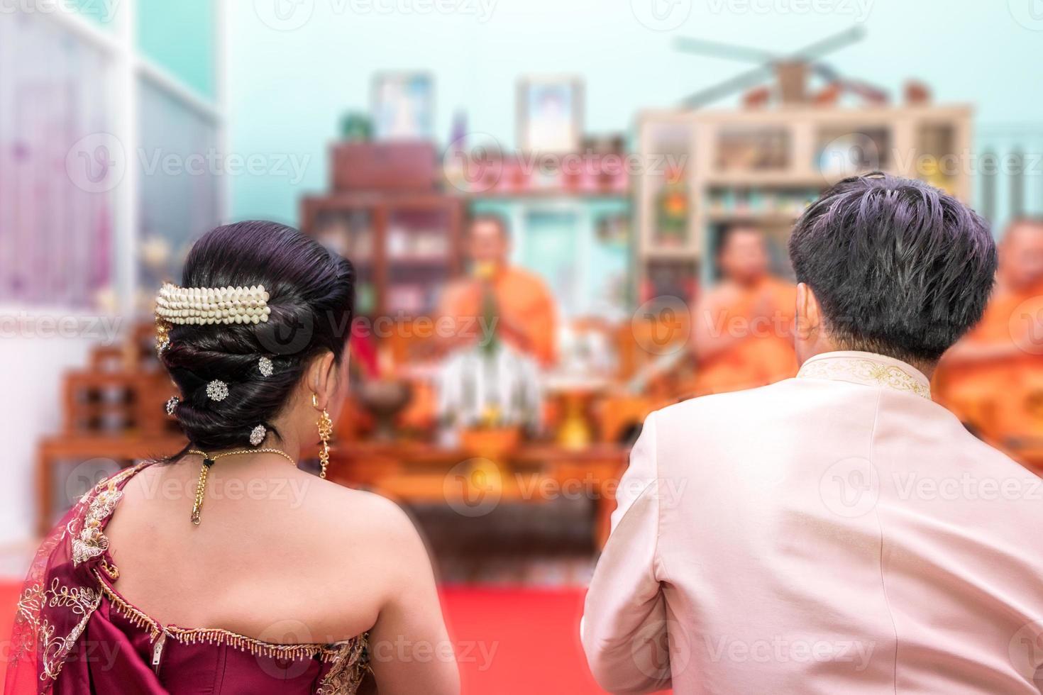 Behind the bride and groom and monk. photo