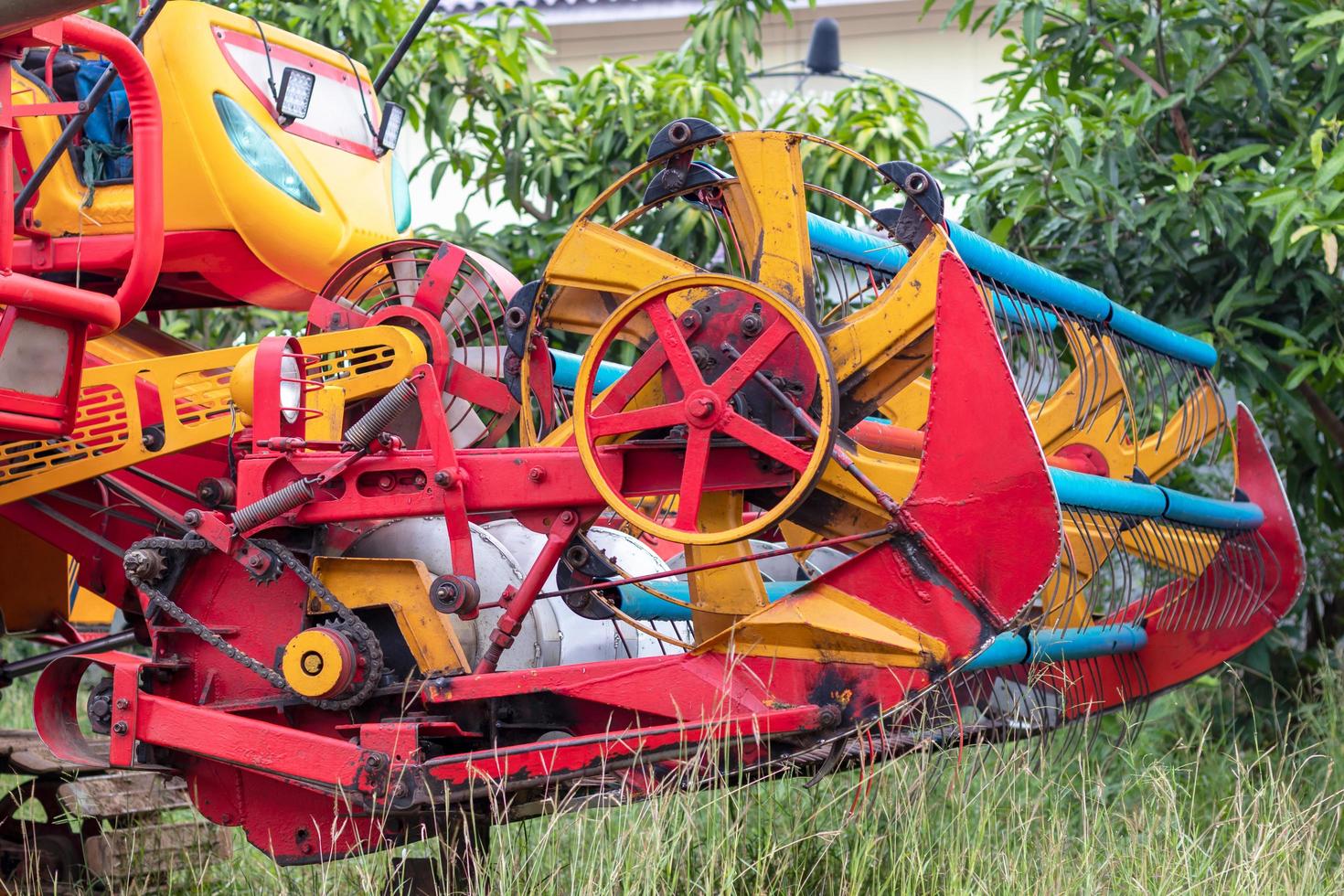 The front of the combine harvesters is yellow and red. photo