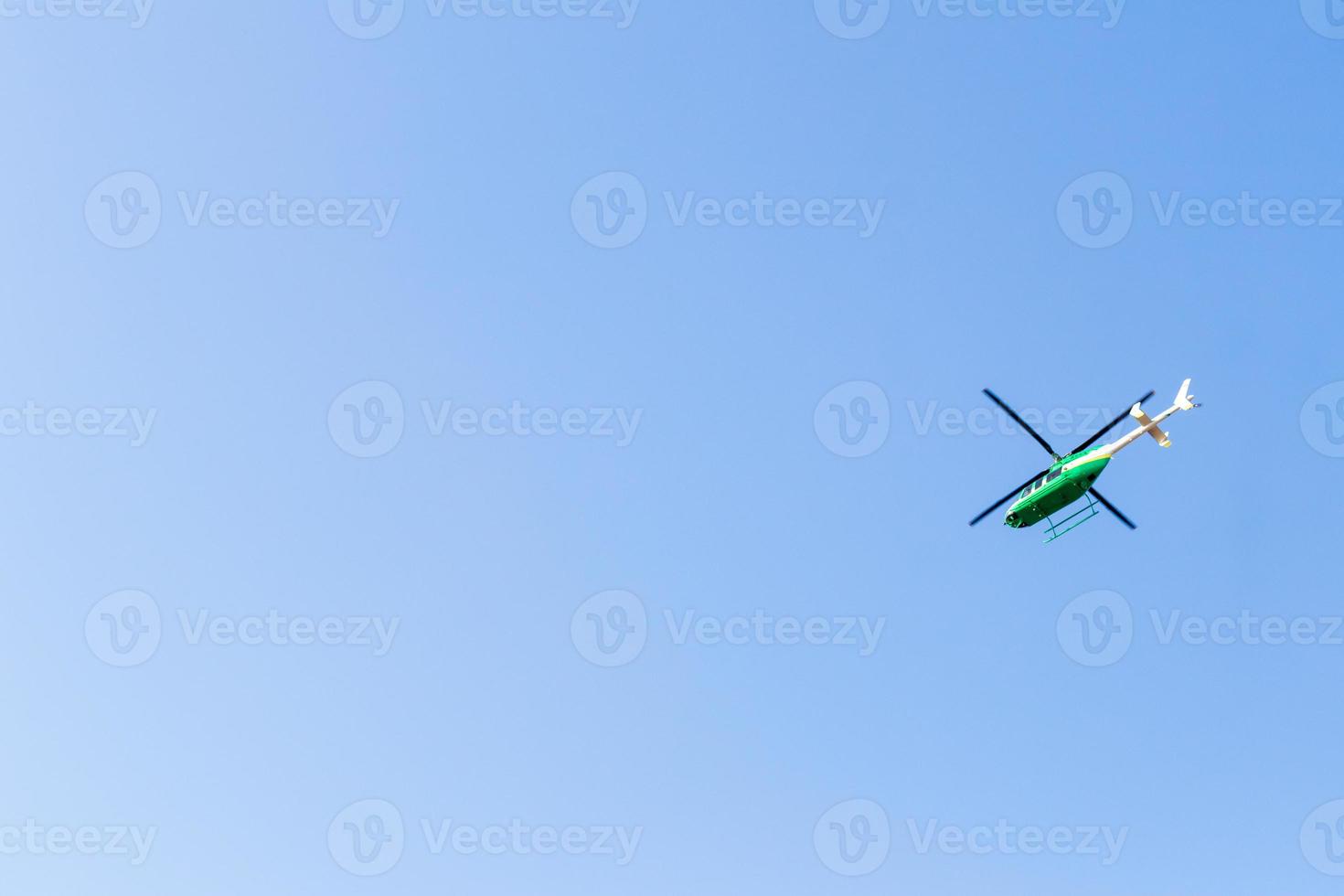 Green helicopter in the sky. photo