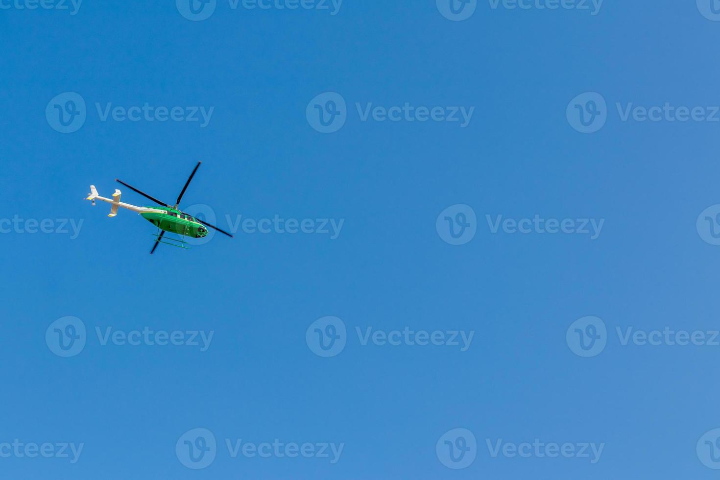 Green helicopter in the sky. photo