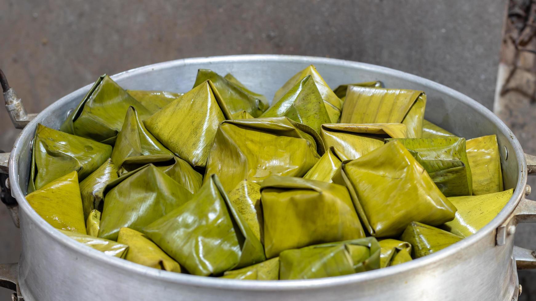 Thai sweets triangle wrapped with banana leaves. photo