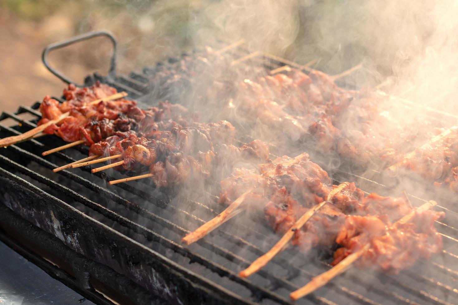 brochetas de pollo a la parrilla con humo. foto