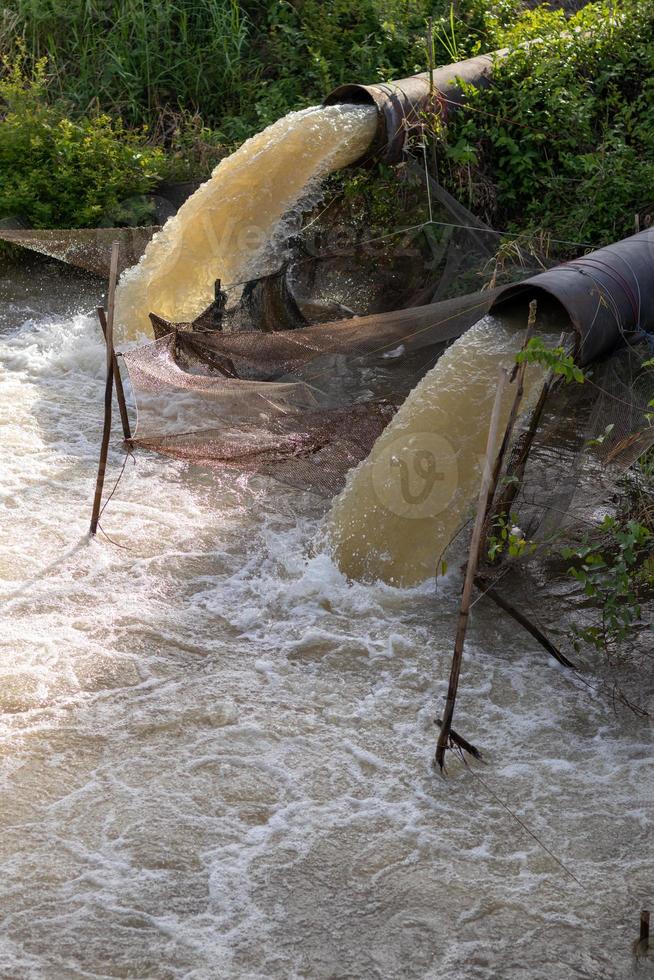 el agua fluye desde la alcantarilla hasta el canal. foto