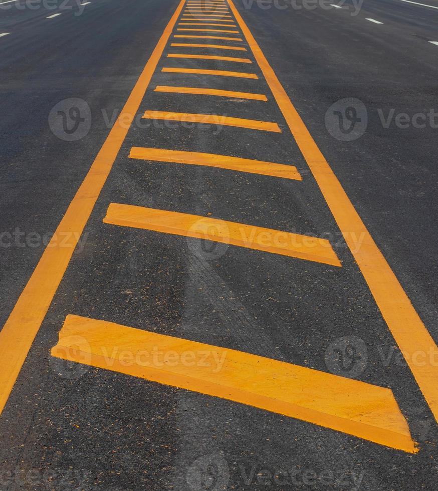 Yellow line symbol on a new paved road. photo