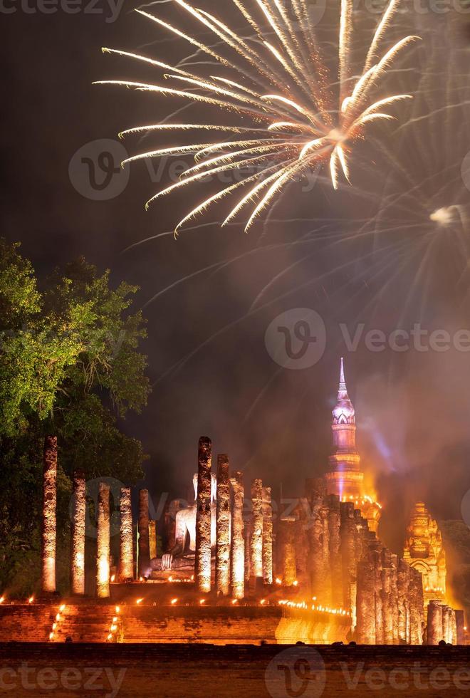 fuegos artificiales de colores con el antiguo templo de sukhothai por la noche. foto