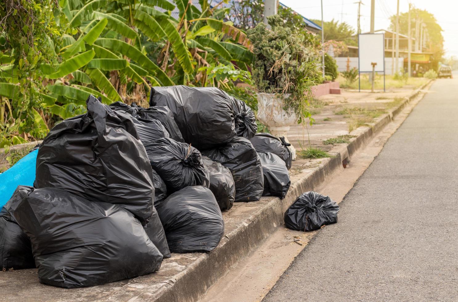 Many black plastic bags filled with garbage. photo