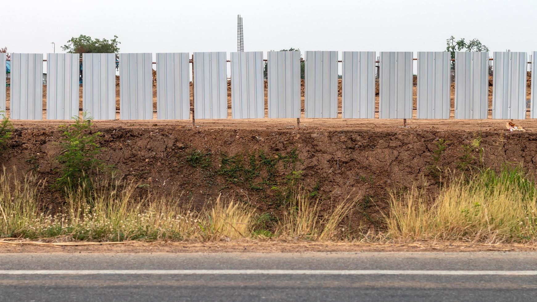 Galvanized fence wall on the ground near the road. photo