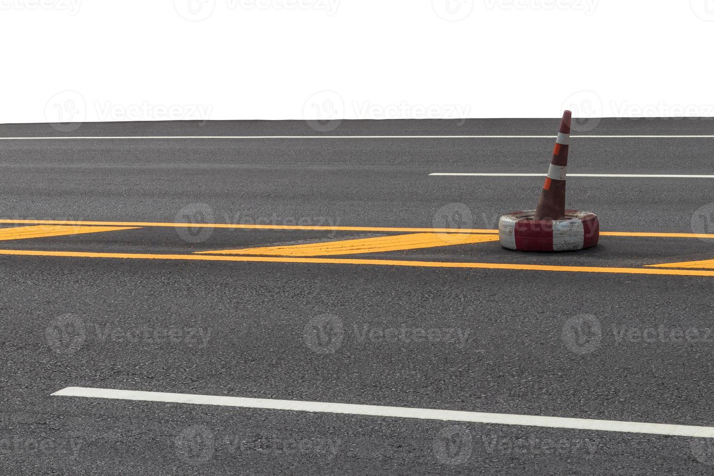 Old rubber cone on the yellow line of the road. photo