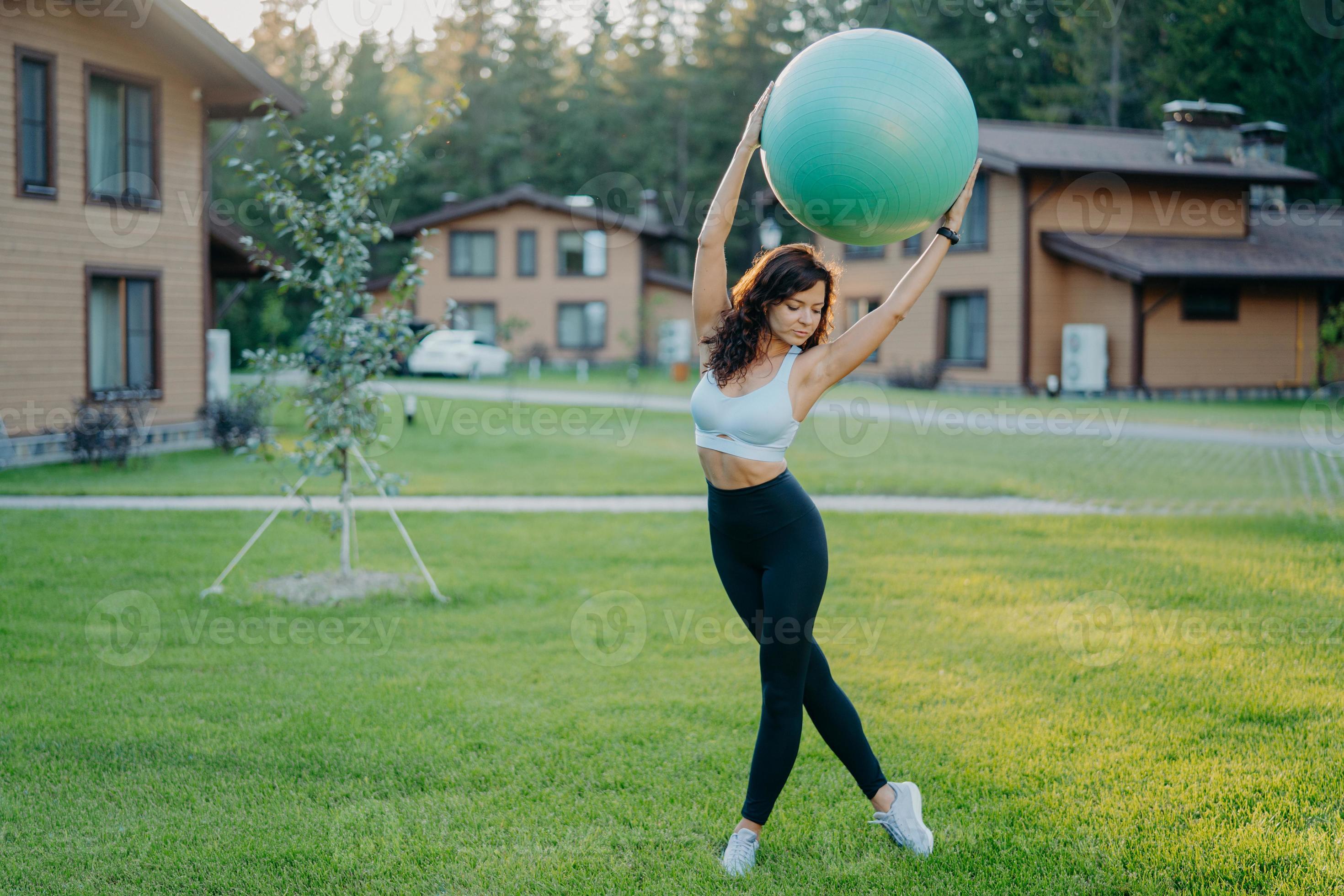 Slim motivated brunette woman dressed in cropped top and leggings